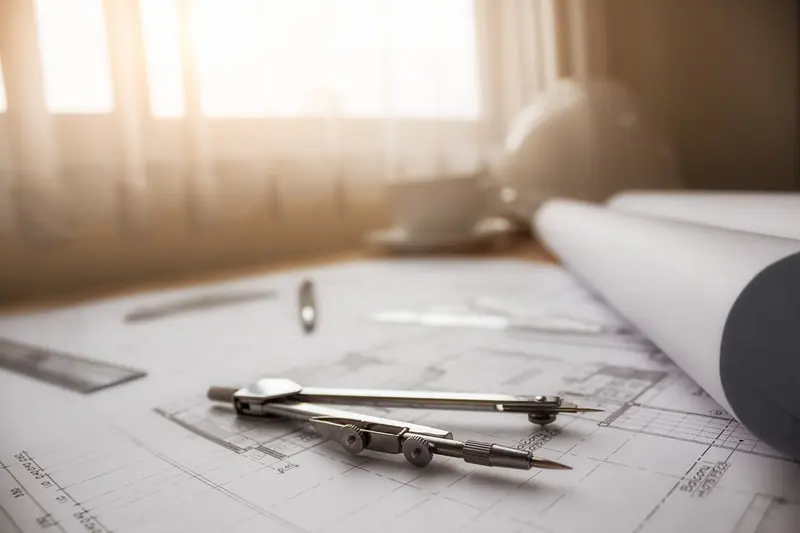 فرجار ومسطرة فوق مخططات هندسية